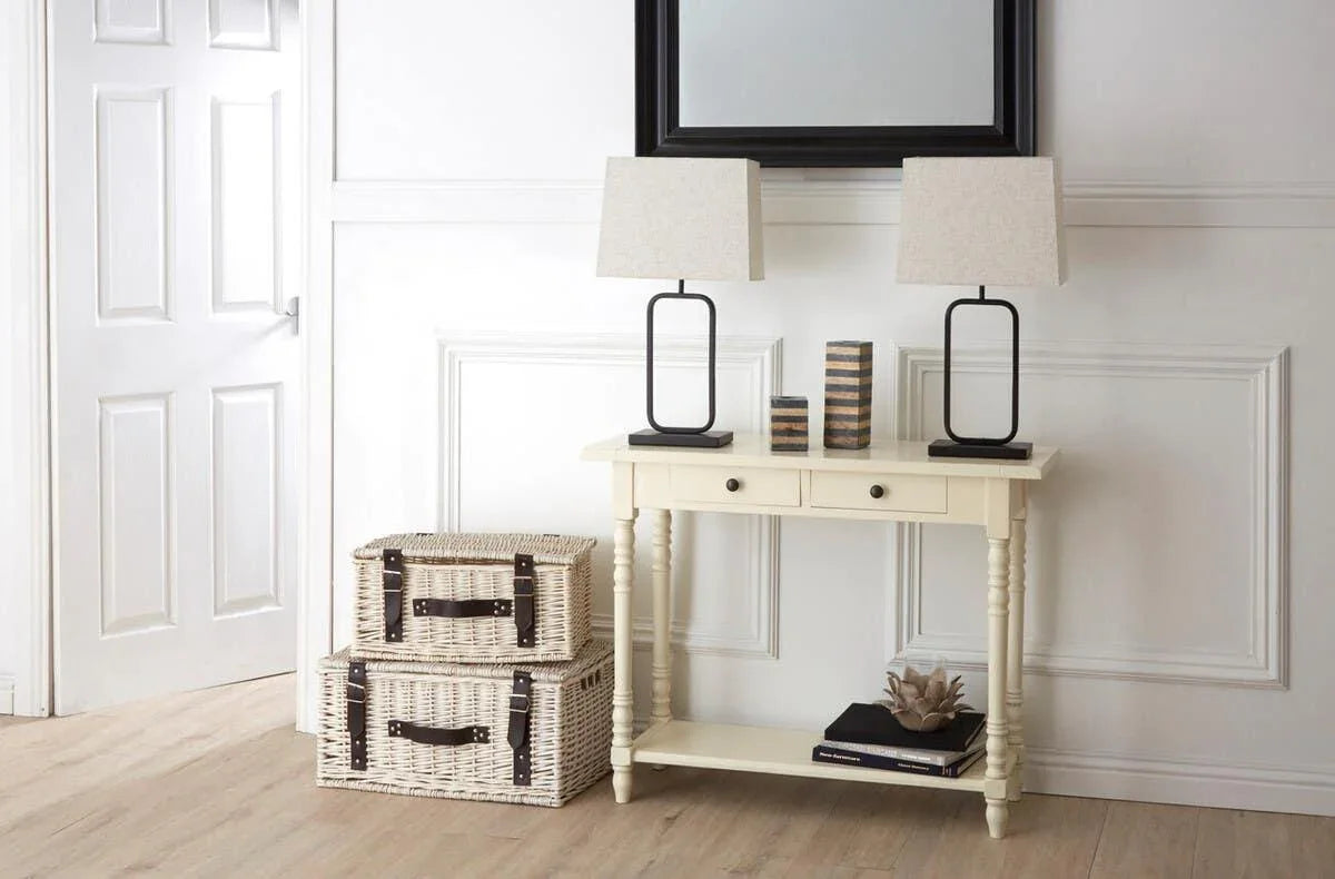 Cream hallway console table with two lamps, wicker baskets, and mirror above