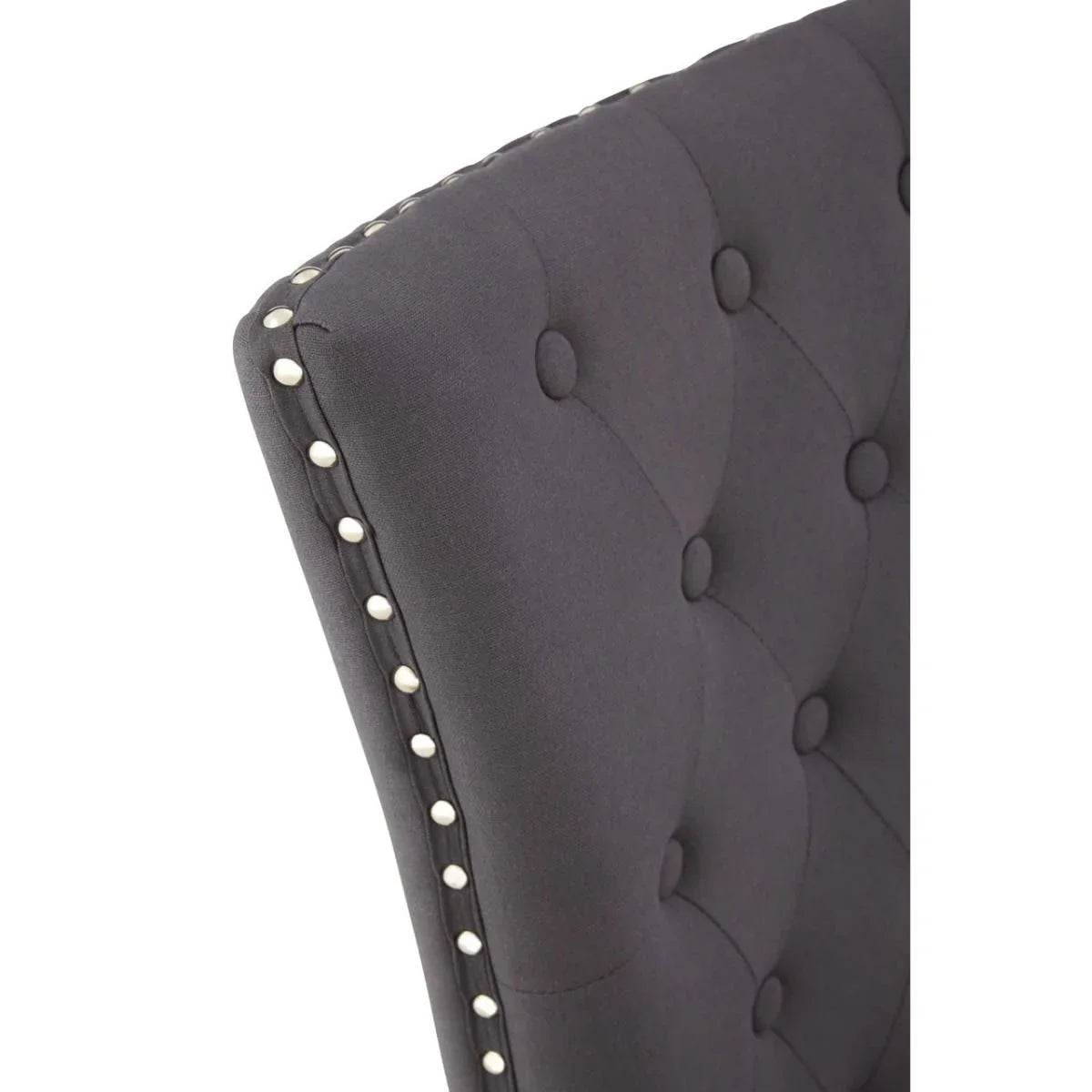 Dark grey dining chair with button tufted backrest and silver stud detailing