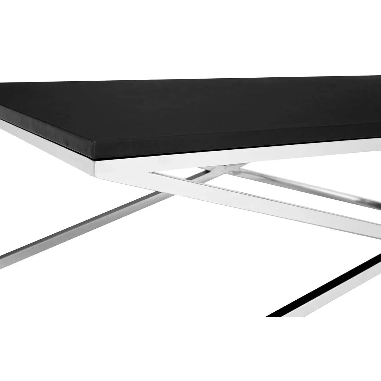 Close view of modern black dining table with chrome metal legs and rectangular top