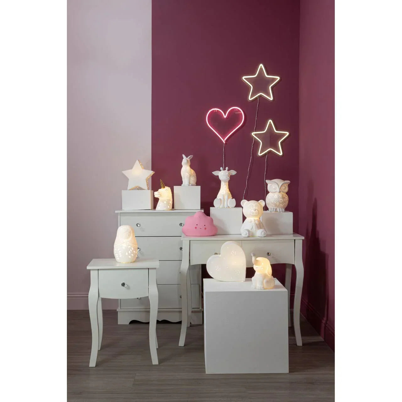 Children’s bedroom lamps and LED wall lights on white nightstands against purple walls
