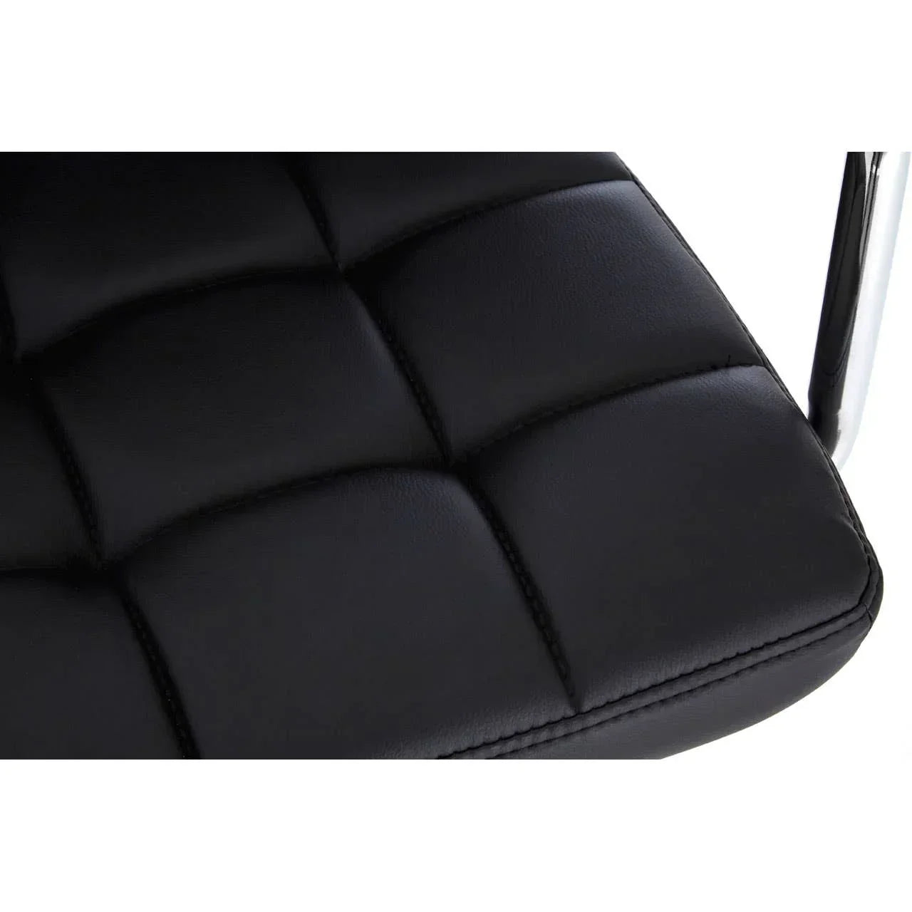Closeup of black faux leather dining chair seat with quilted stitching and chrome frame