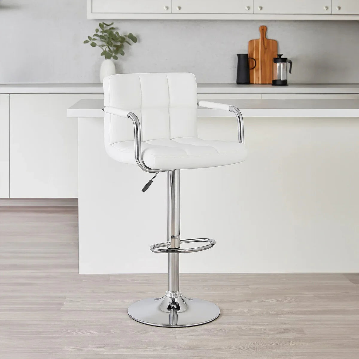 White faux leather bar stool with chrome base and footrest in modern kitchen setting