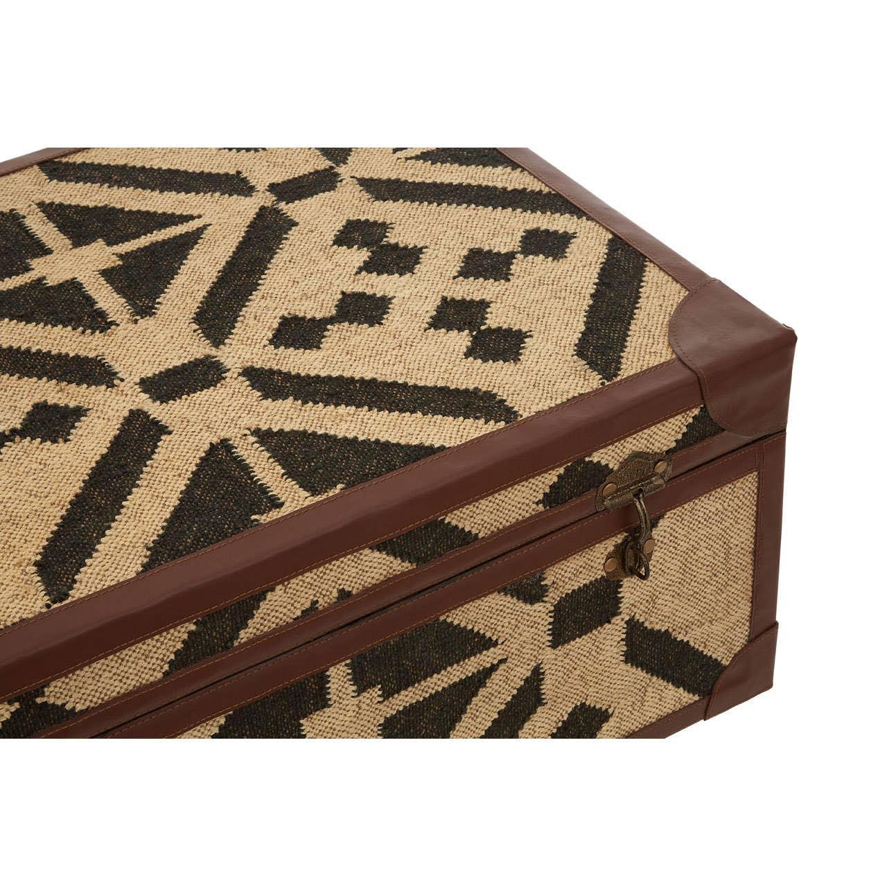 Woven storage trunk with geometric black pattern and brown leather trim, corner angle view