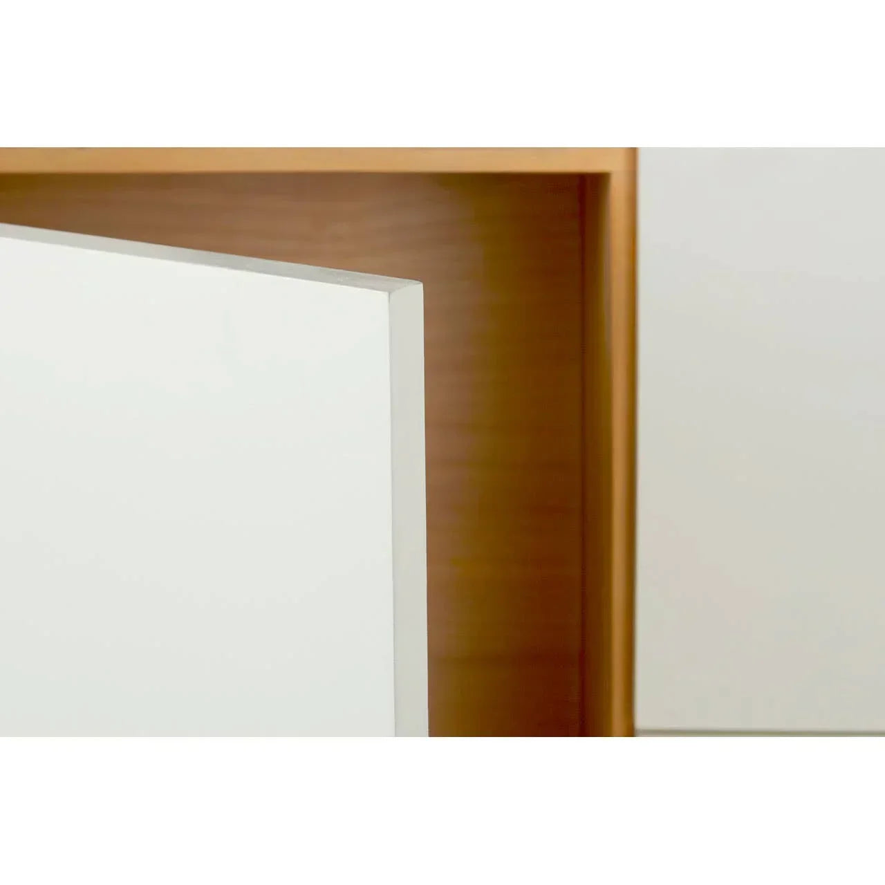White cabinet door with wood effect frame, close-up of edge and open shelf detail