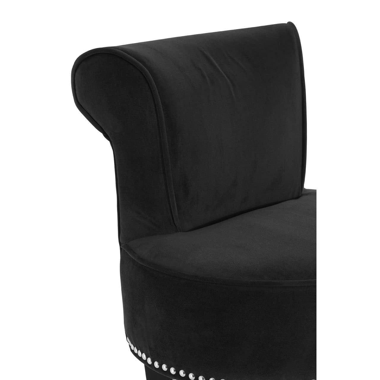 Black velvet accent chair with stud detailing and curved backrest close-up