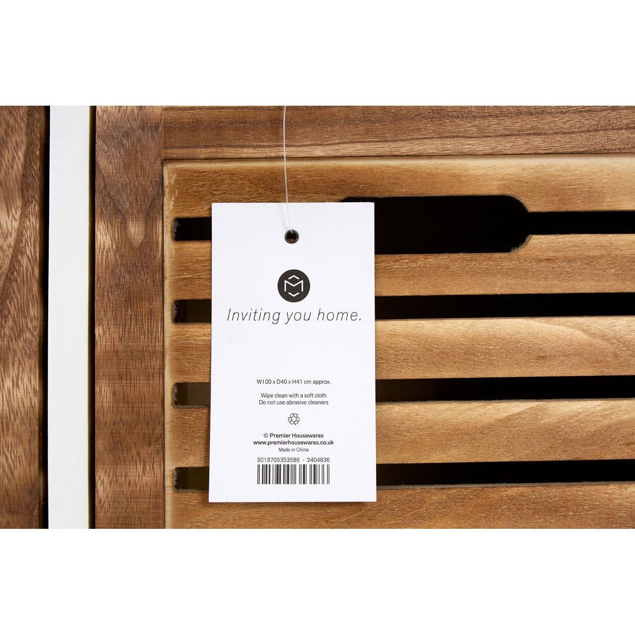 Natural wood drawer chest featuring a sleek design with horizontal slats on the front. A product tag is attached, displaying branding and information. The wood finish showcases a warm, rich tone