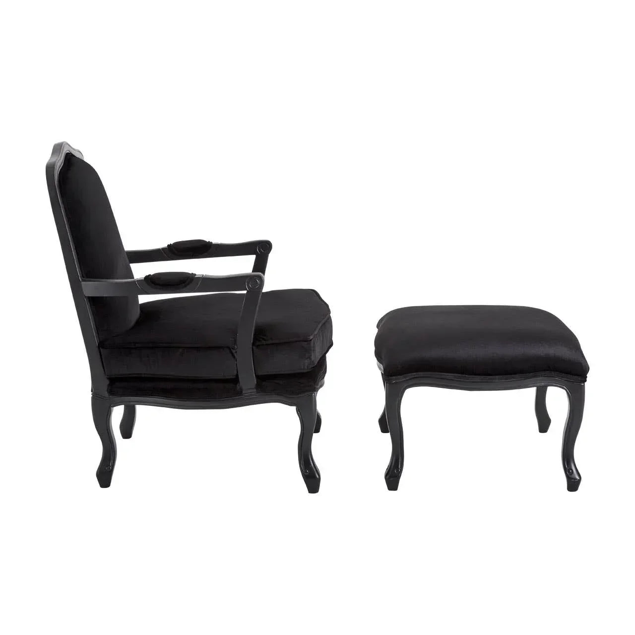 Black upholstered armchair with matching footstool and carved wooden legs side view