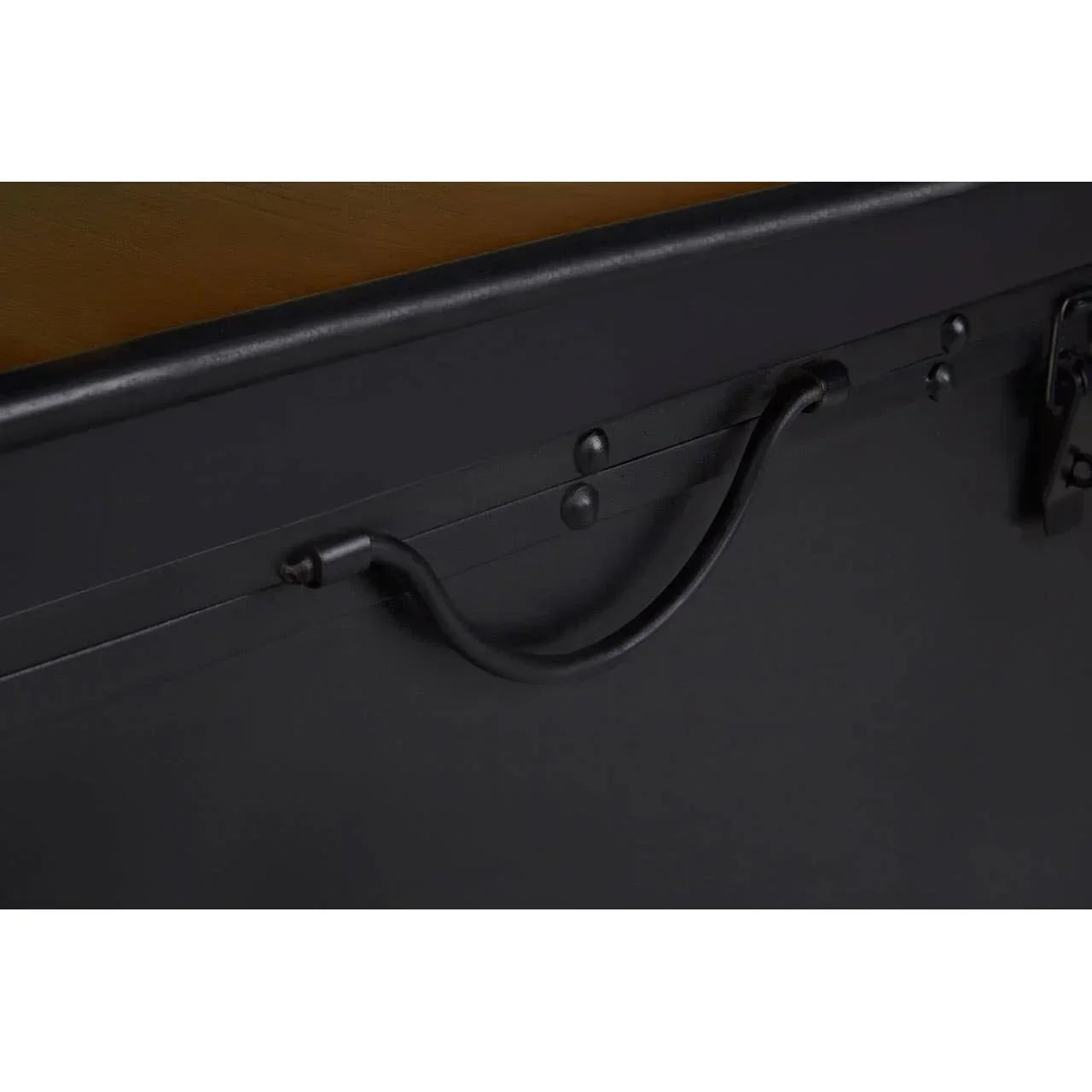 Closeup of black metal handle on storage trunk with matte finish