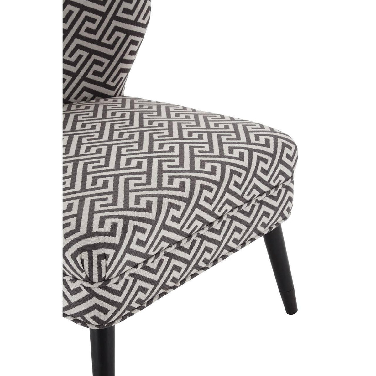 Grey patterned accent chair with Greek key fabric and black tapered legs close-up