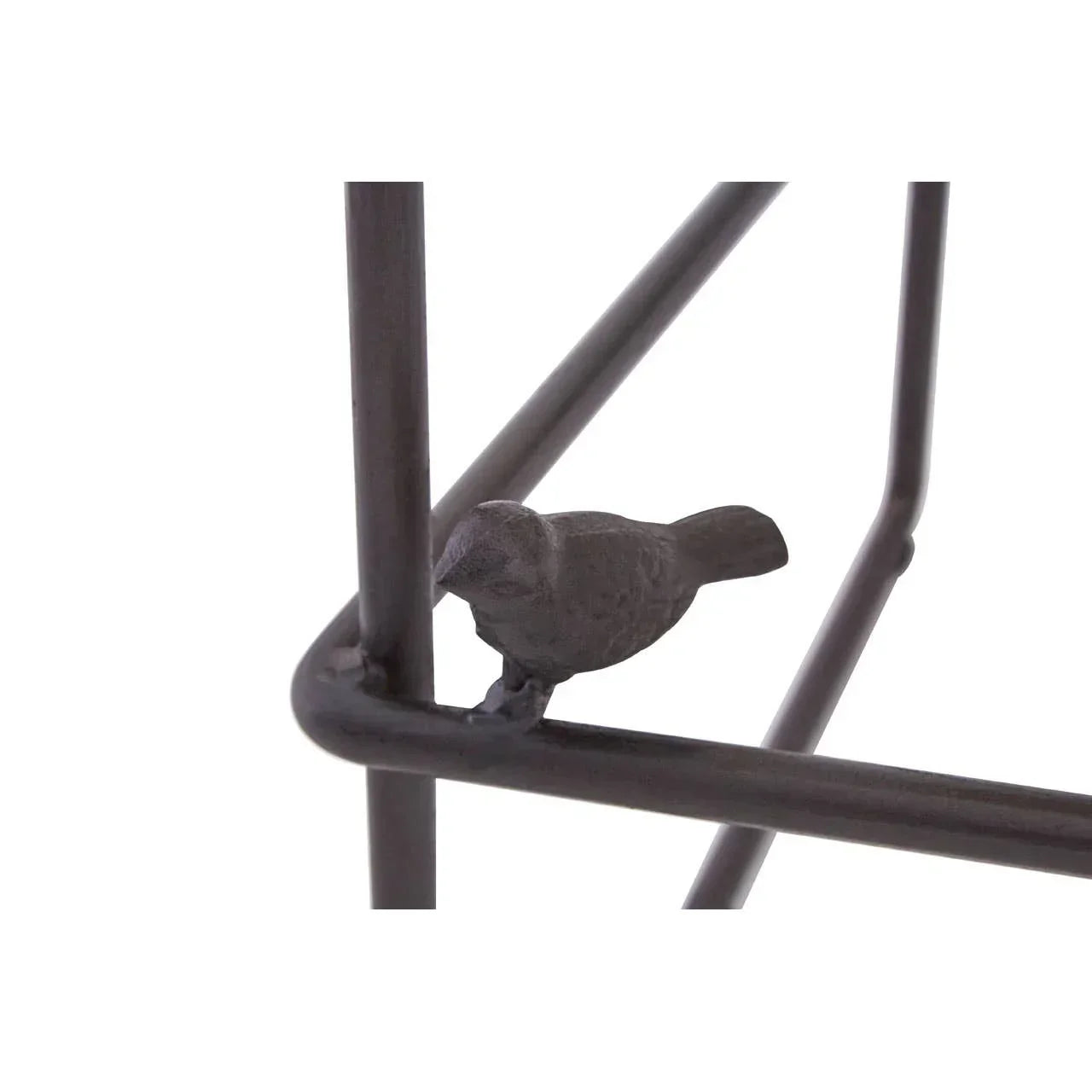 Metal side table corner with small bird figurine accent on black frame