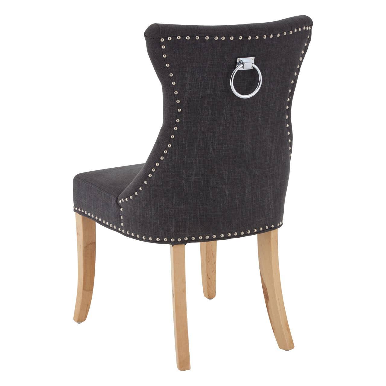 Black fabric dining chair with studded trim, chrome knocker back, and light wooden legs
