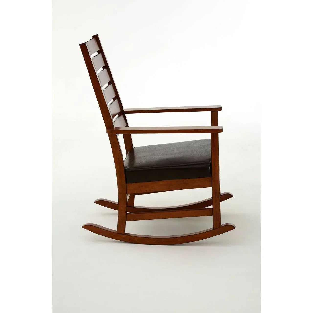 Side view of wooden rocking chair with dark cushioned seat and slatted backrest