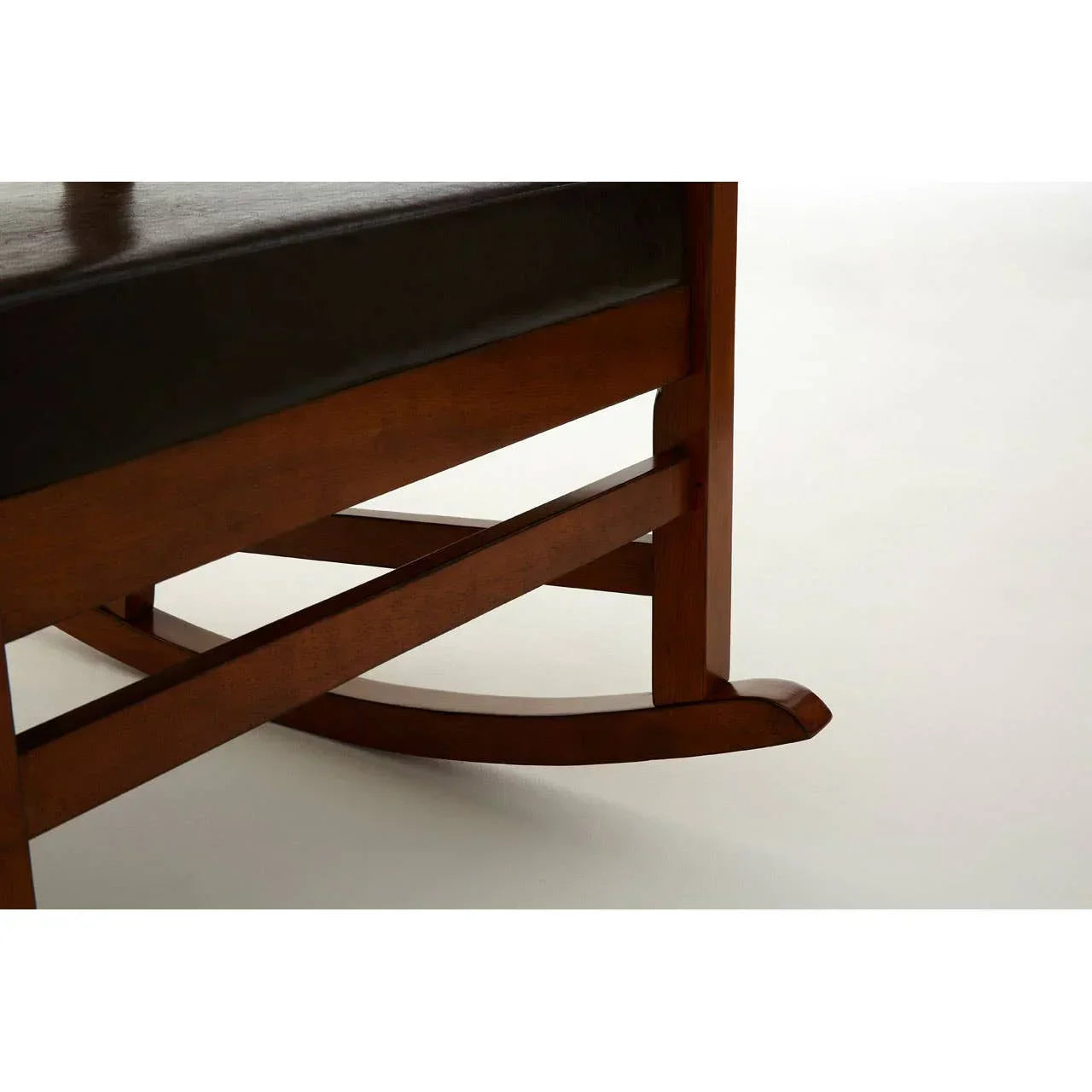 Wooden rocking chair base with dark cushion close-up on white background