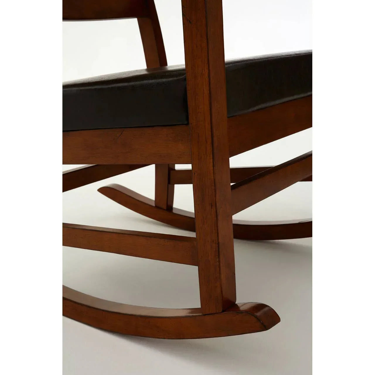 Wooden rocking chair base with dark cushioned seat in close-up side view