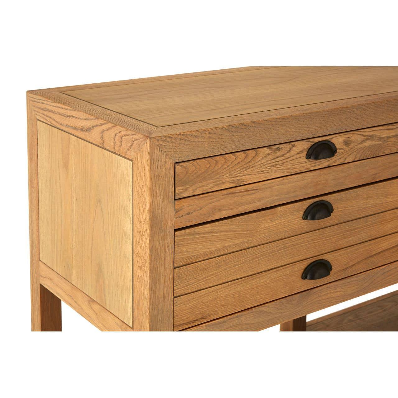 Oak wood chest of drawers with three metal cup handles, closeup of drawer fronts