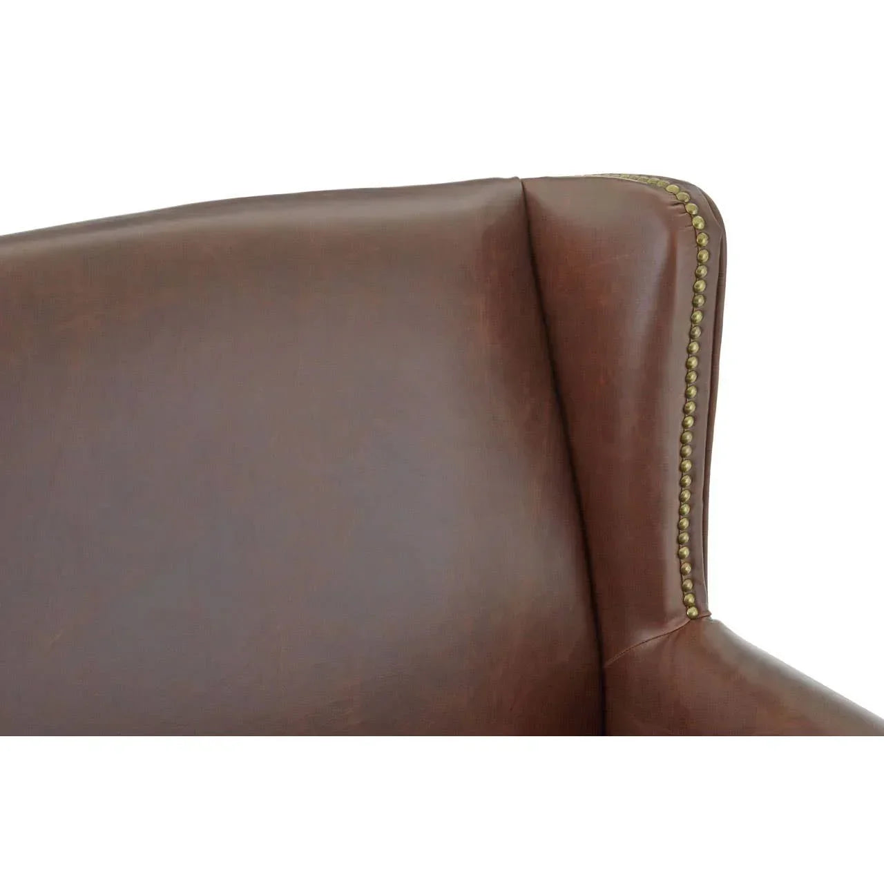 Brown leather armchair backrest with brass stud detailing close up