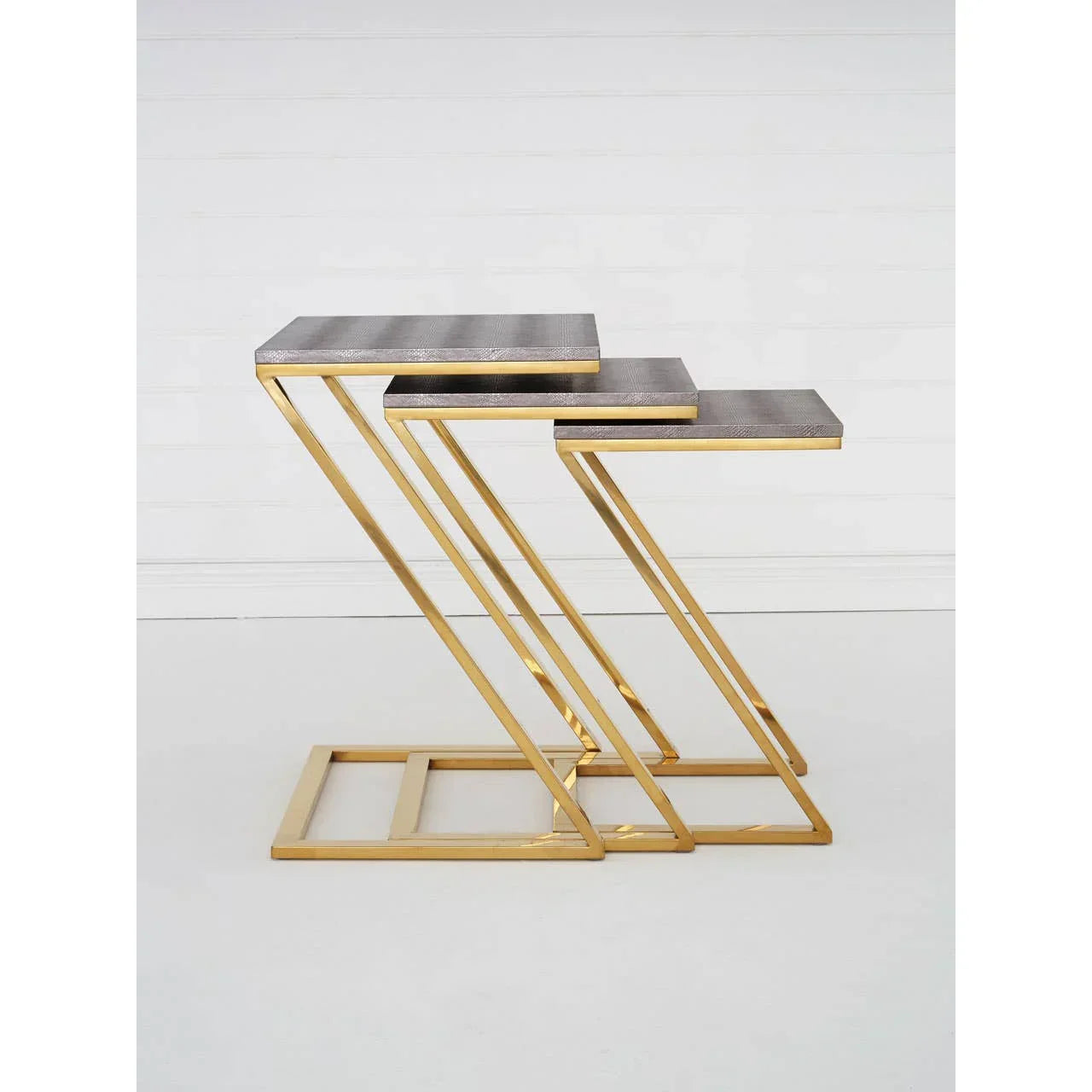 Set of three nesting tables with gold metal frames and textured grey tops