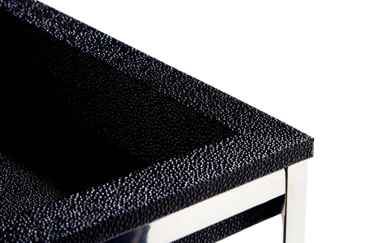 Closeup of black textured side table with chrome legs and modern finish