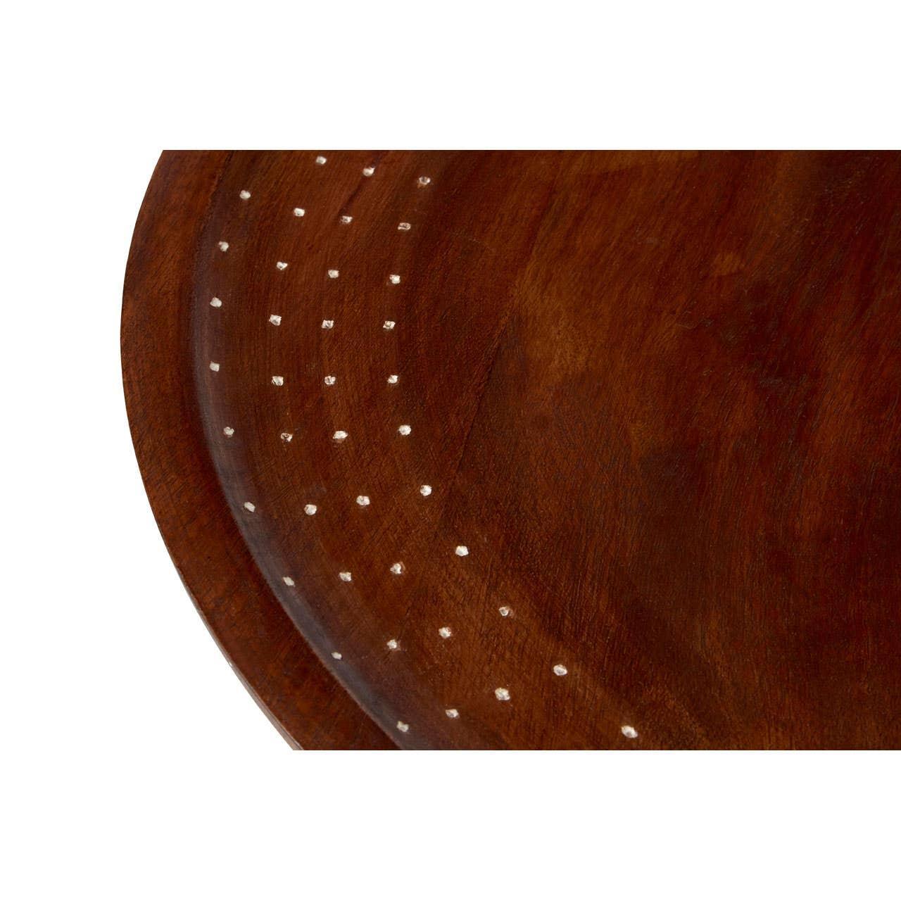 Close-up of round wooden table top with dotted inlay detail