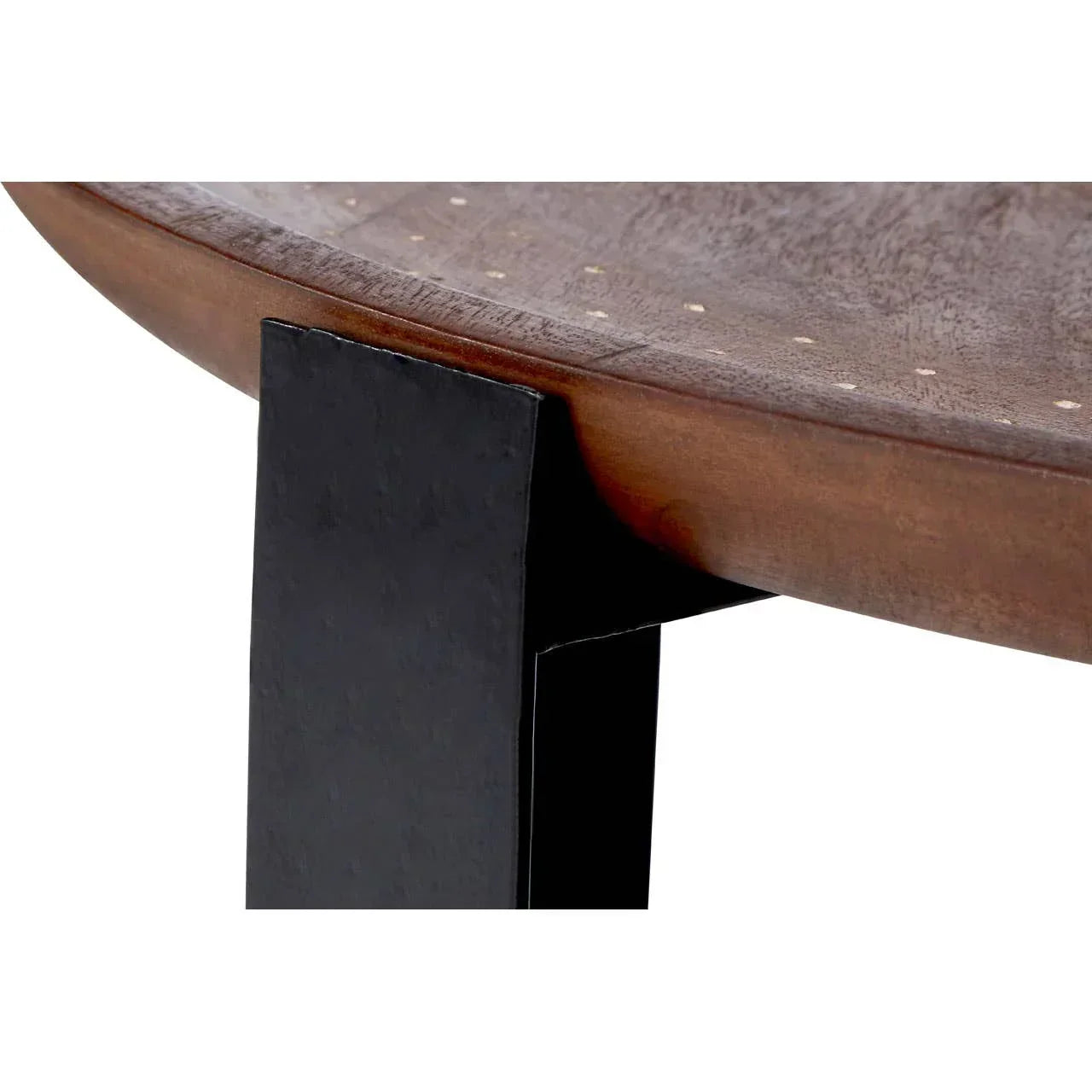 Closeup of wooden dining table top with black metal leg and studded detail