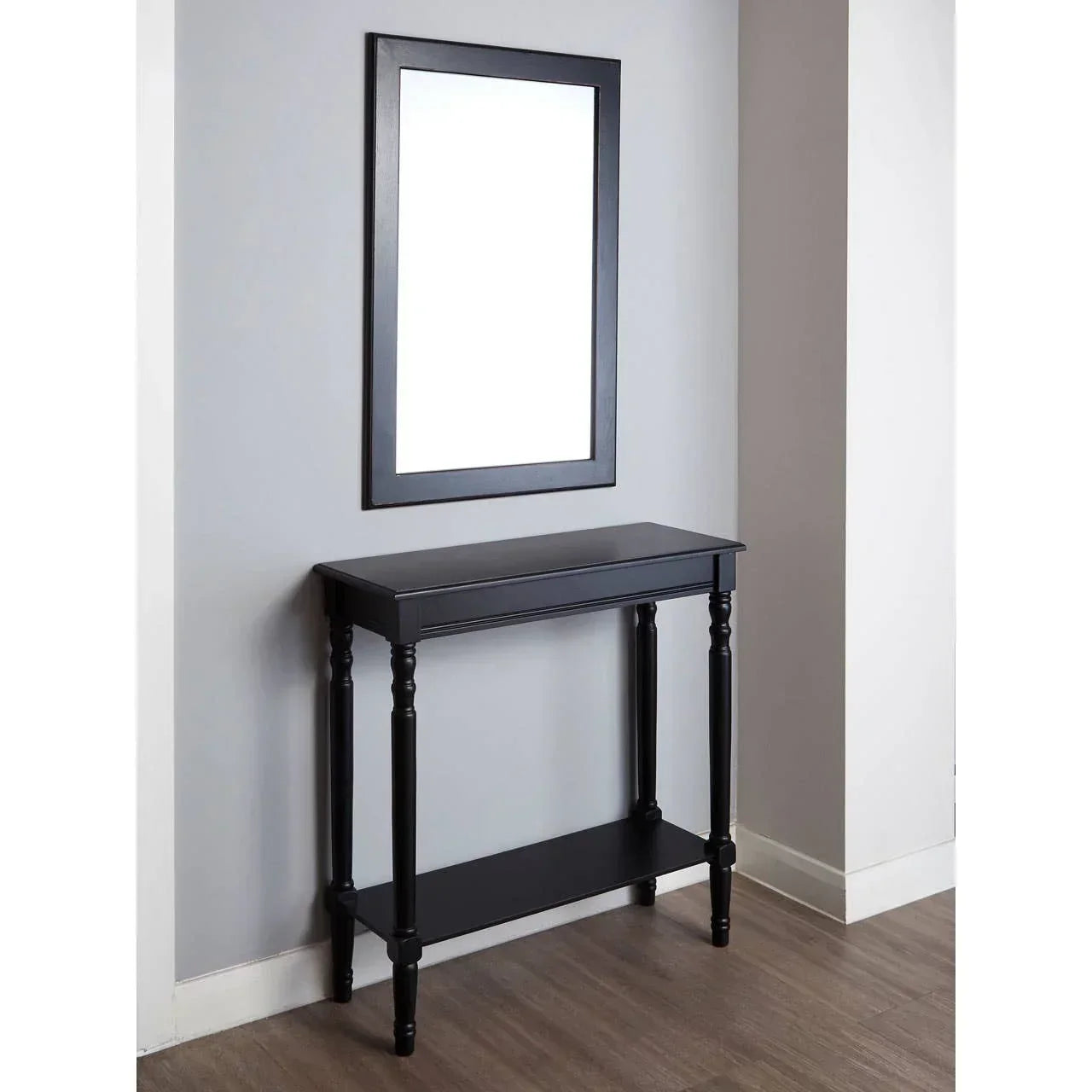 Black console table with lower shelf and matching black framed wall mirror in hallway