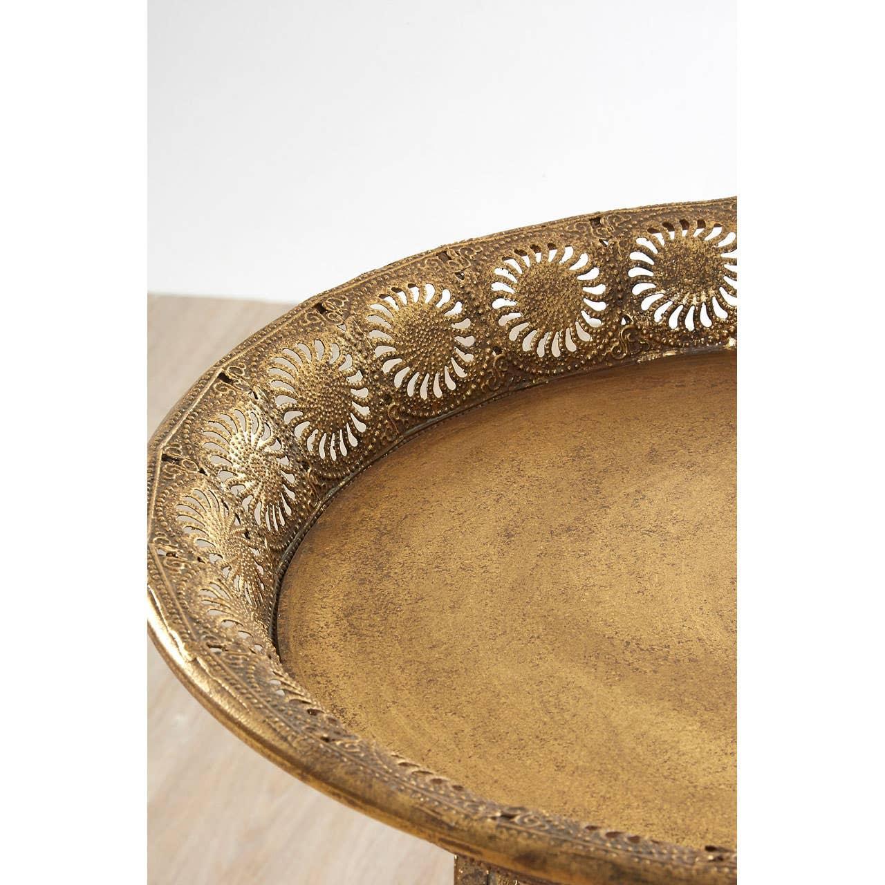 Brass tray table with ornate cutout floral edge detail, close-up of textured surface