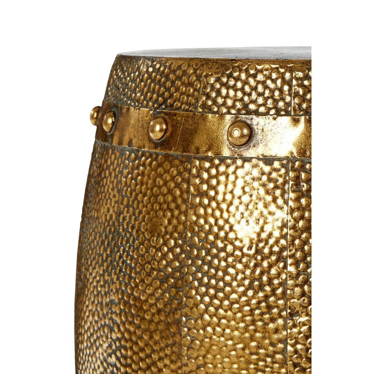 Close-up of hammered gold metal side table with studded detail