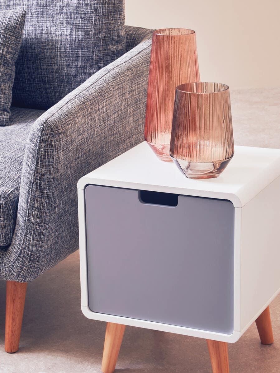 Grey fabric sofa with square side table, wooden legs, and ribbed glass vases