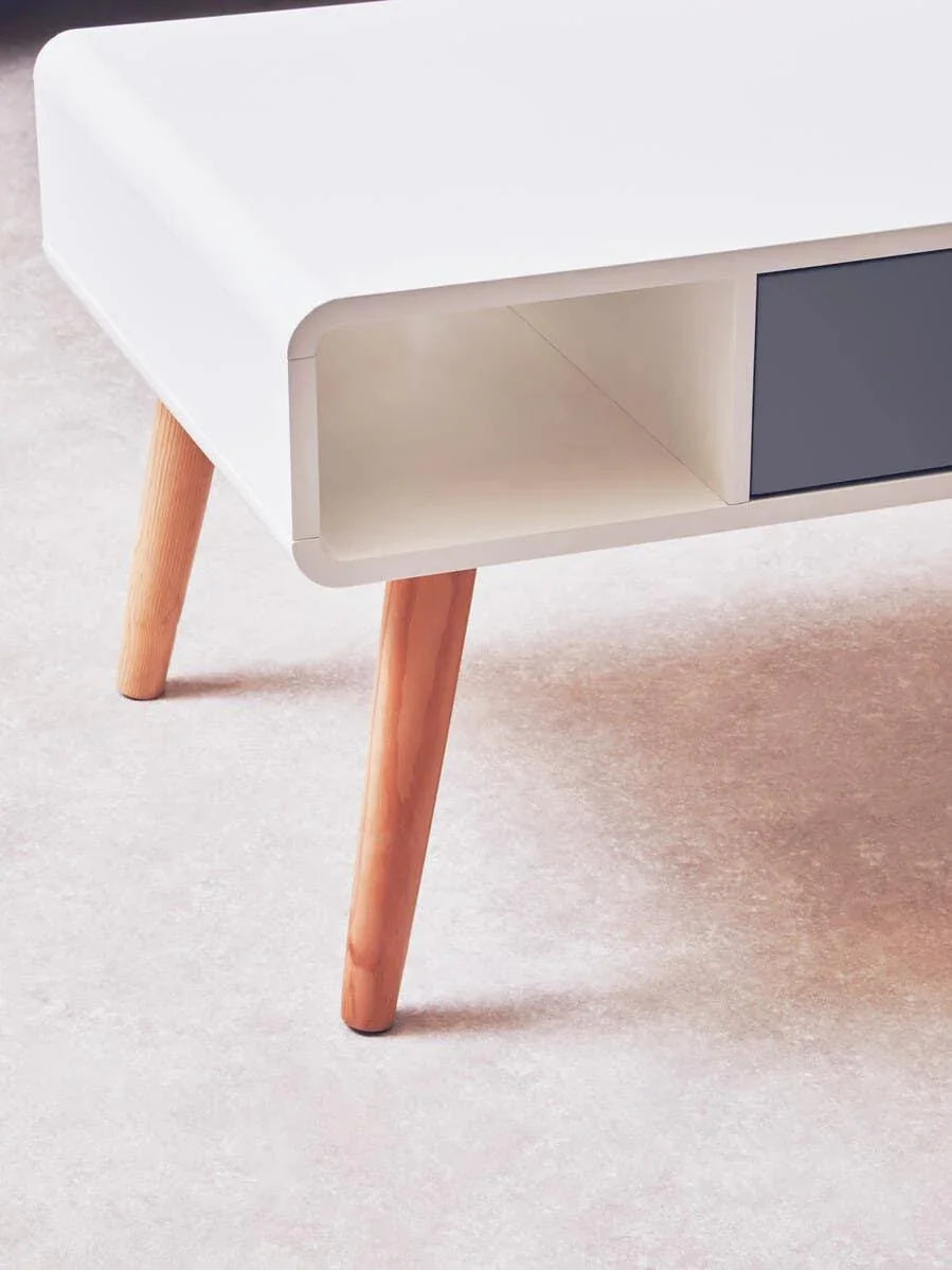 White coffee table with wooden legs and open storage compartment on carpeted floor