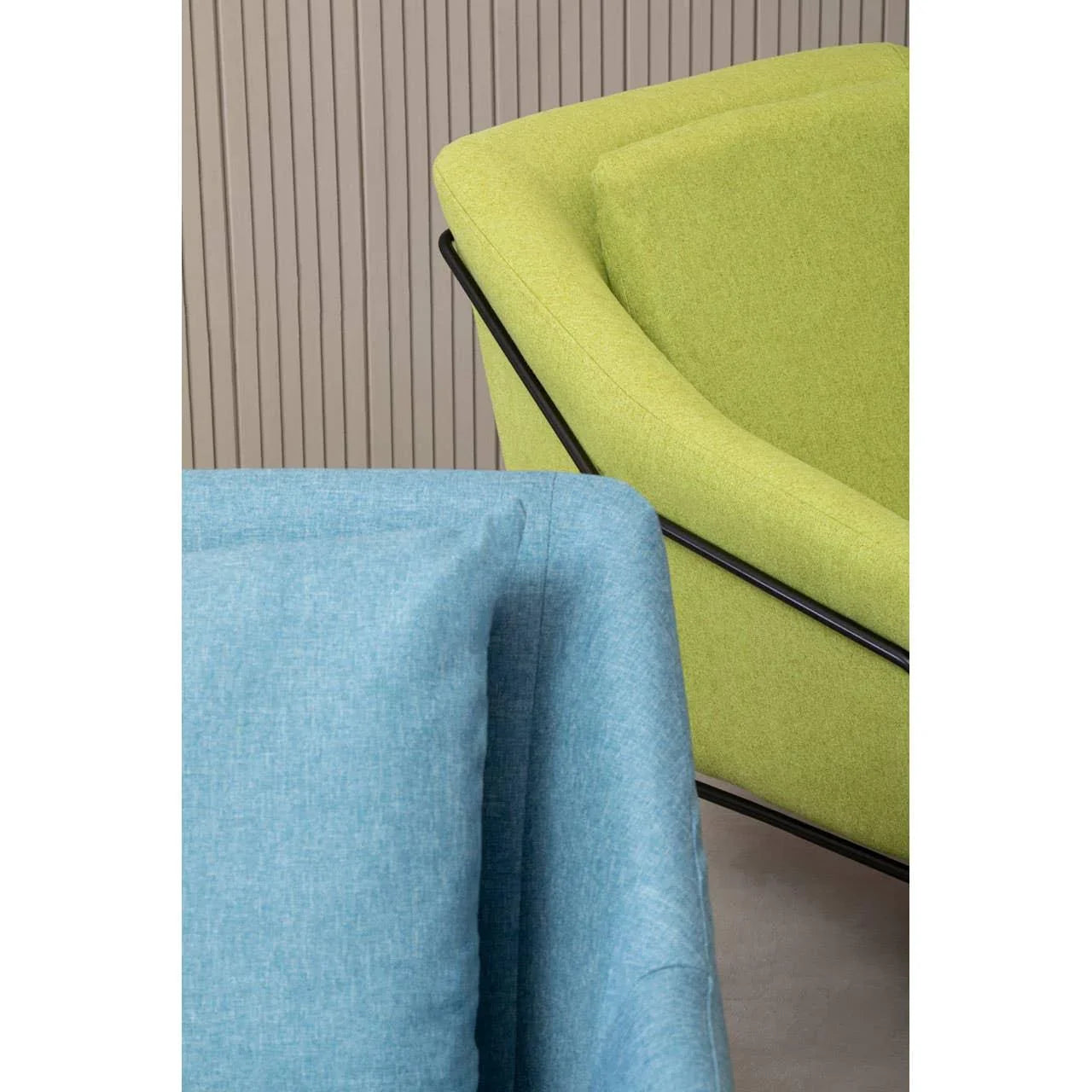 Blue armchair and green fabric armchair with black metal frame detail