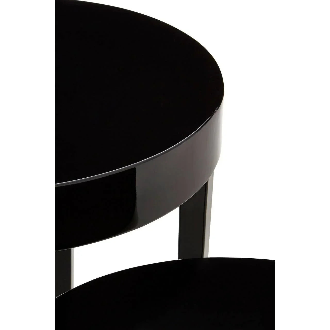 Glossy black round side table with metal legs, close-up of tabletop and edge