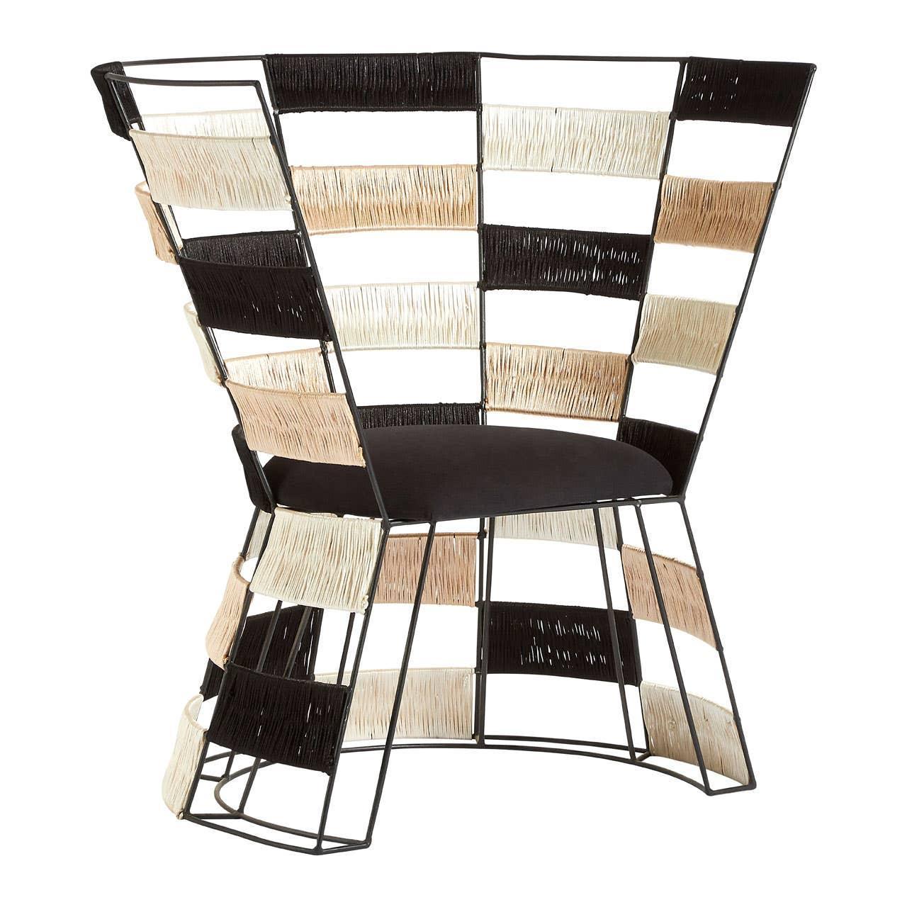 Modern accent chair with woven rattan panels and black metal frame, side angle view
