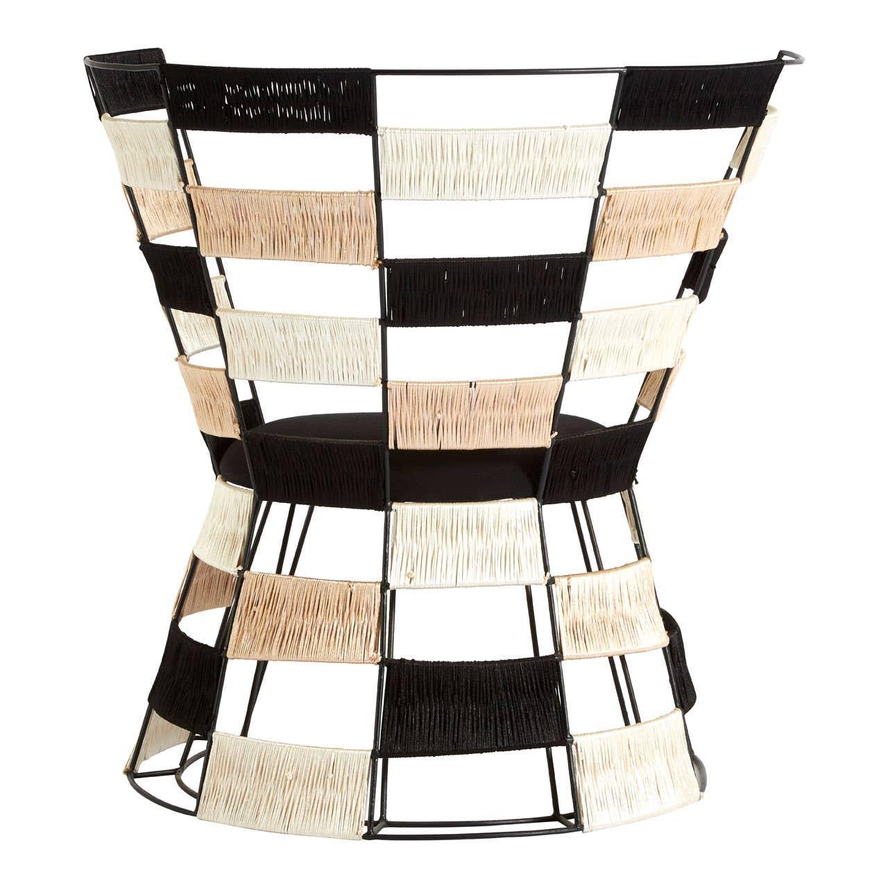 Modern accent chair with black, beige, and cream woven rattan panels on metal frame