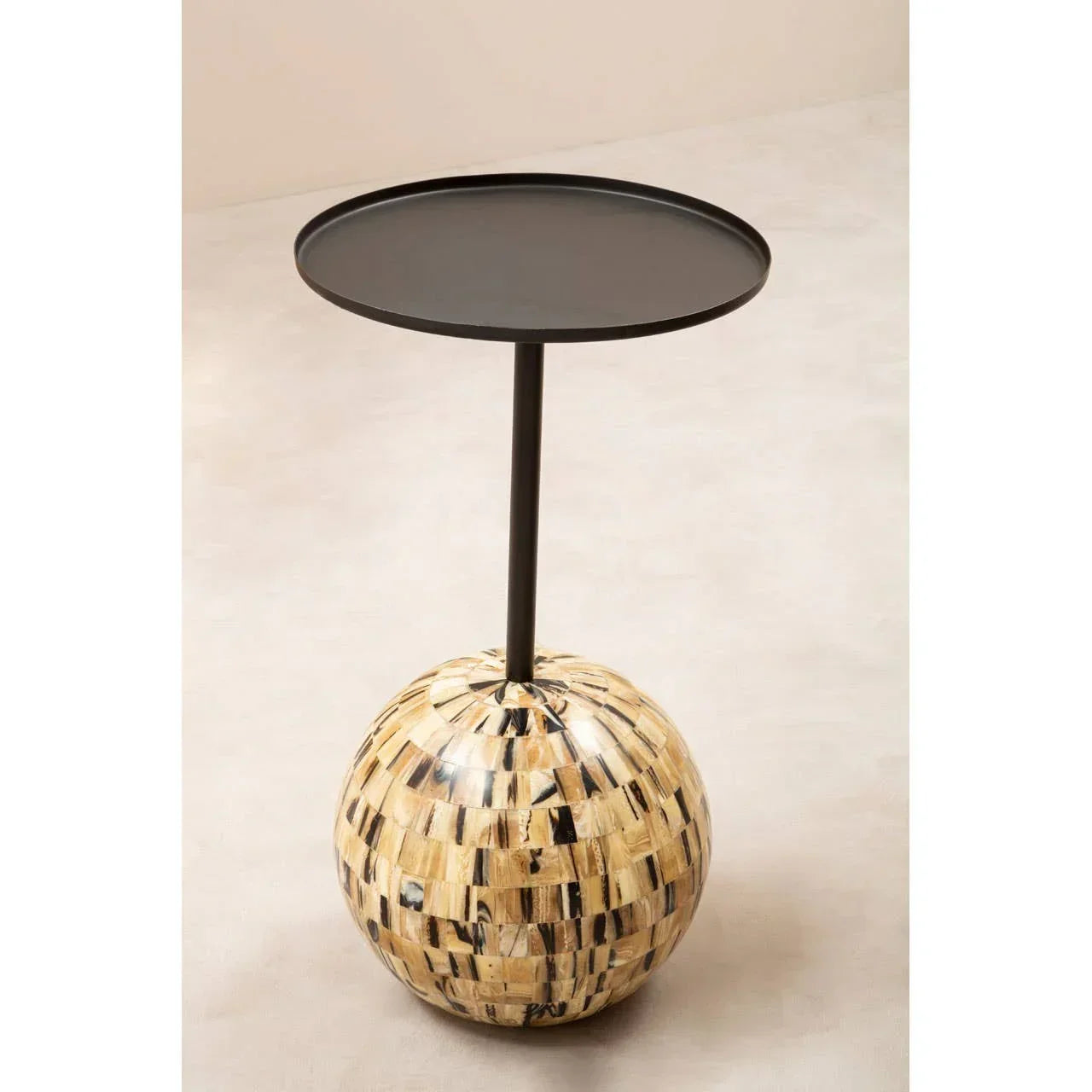 Round black metal side table with mosaic ball base on light floor