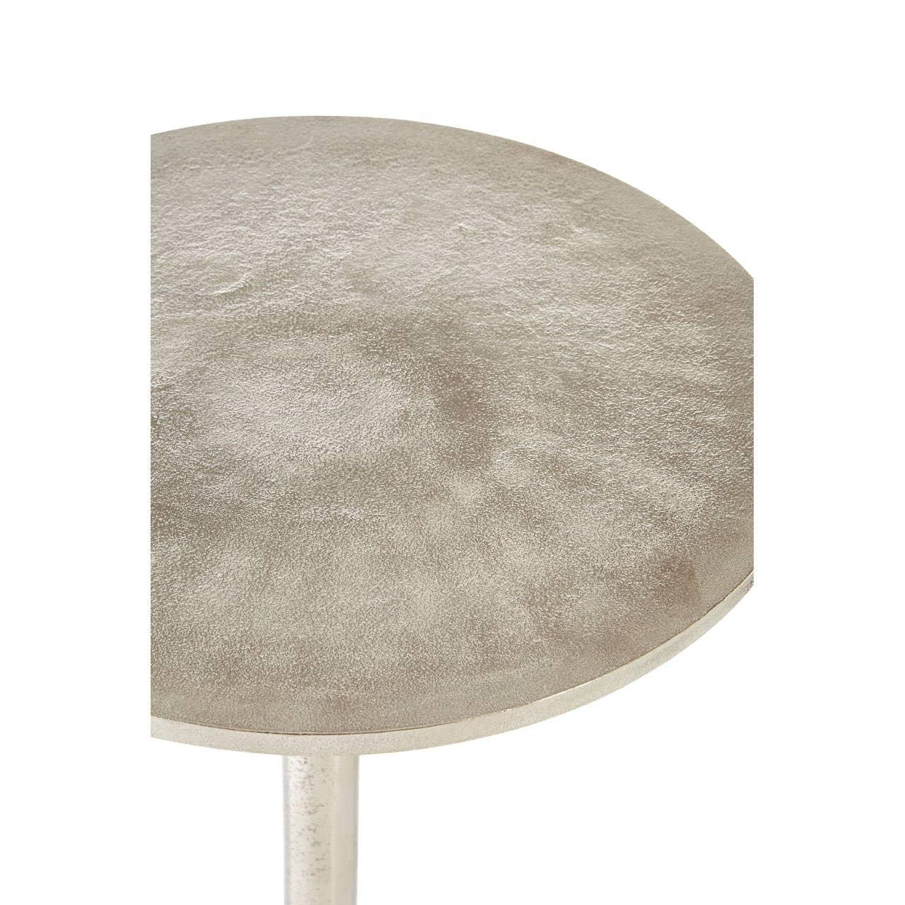 Close view of round metallic side table top with textured silver finish