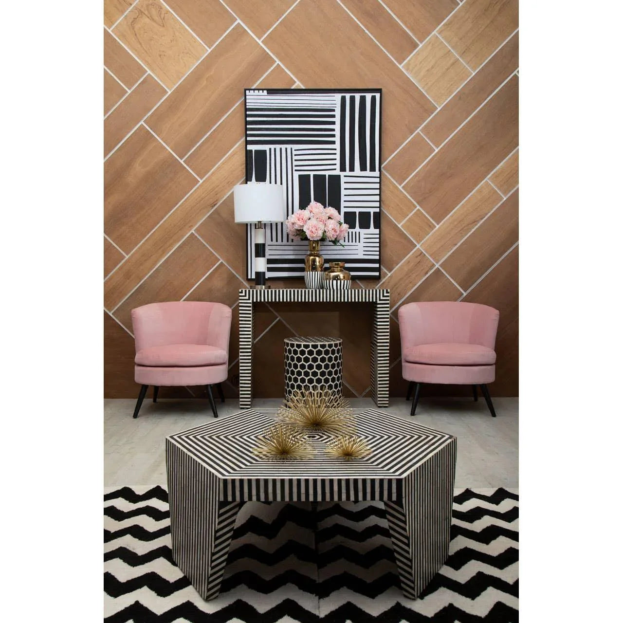 Black and white striped coffee table and console with pink armchairs in modern living room