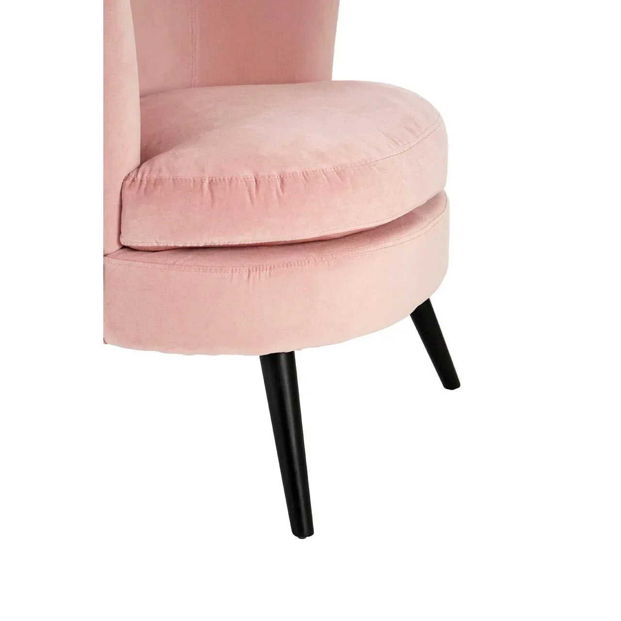 Pink velvet accent chair with black tapered legs, close-up of seat and cushion