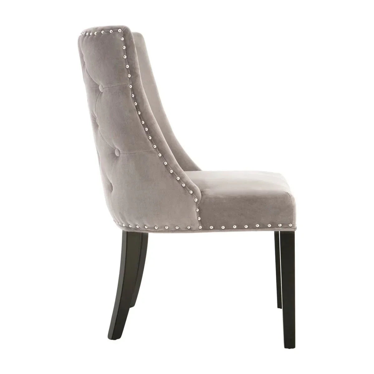 Grey velvet dining chair with button back, silver stud detailing, and dark wood legs, side view