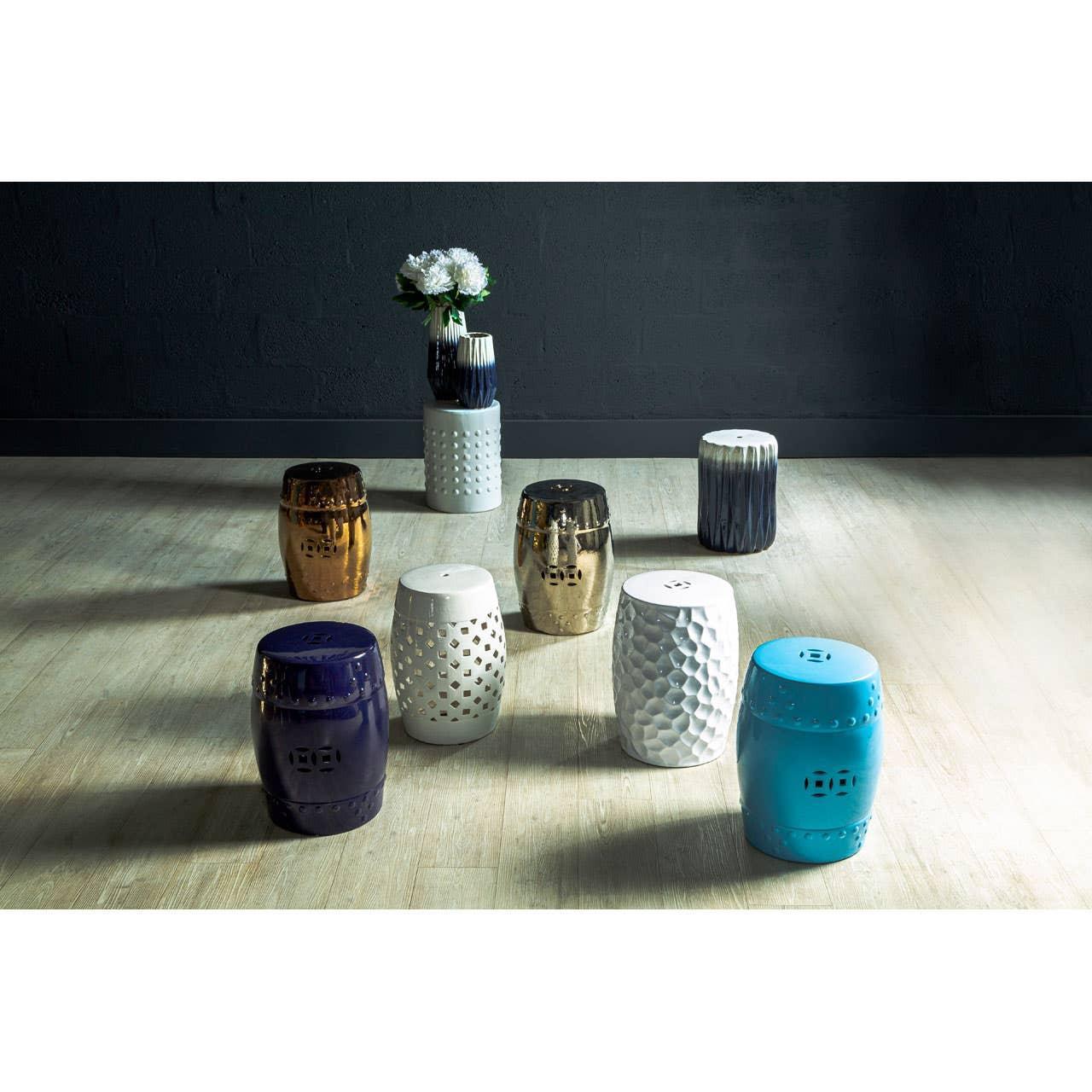 Ceramic garden stools in blue, white, gold, and navy finishes on light wooden floor