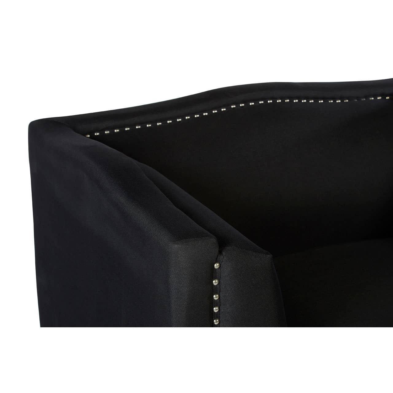 Black fabric sofa corner with silver stud detailing along the arm and backrest