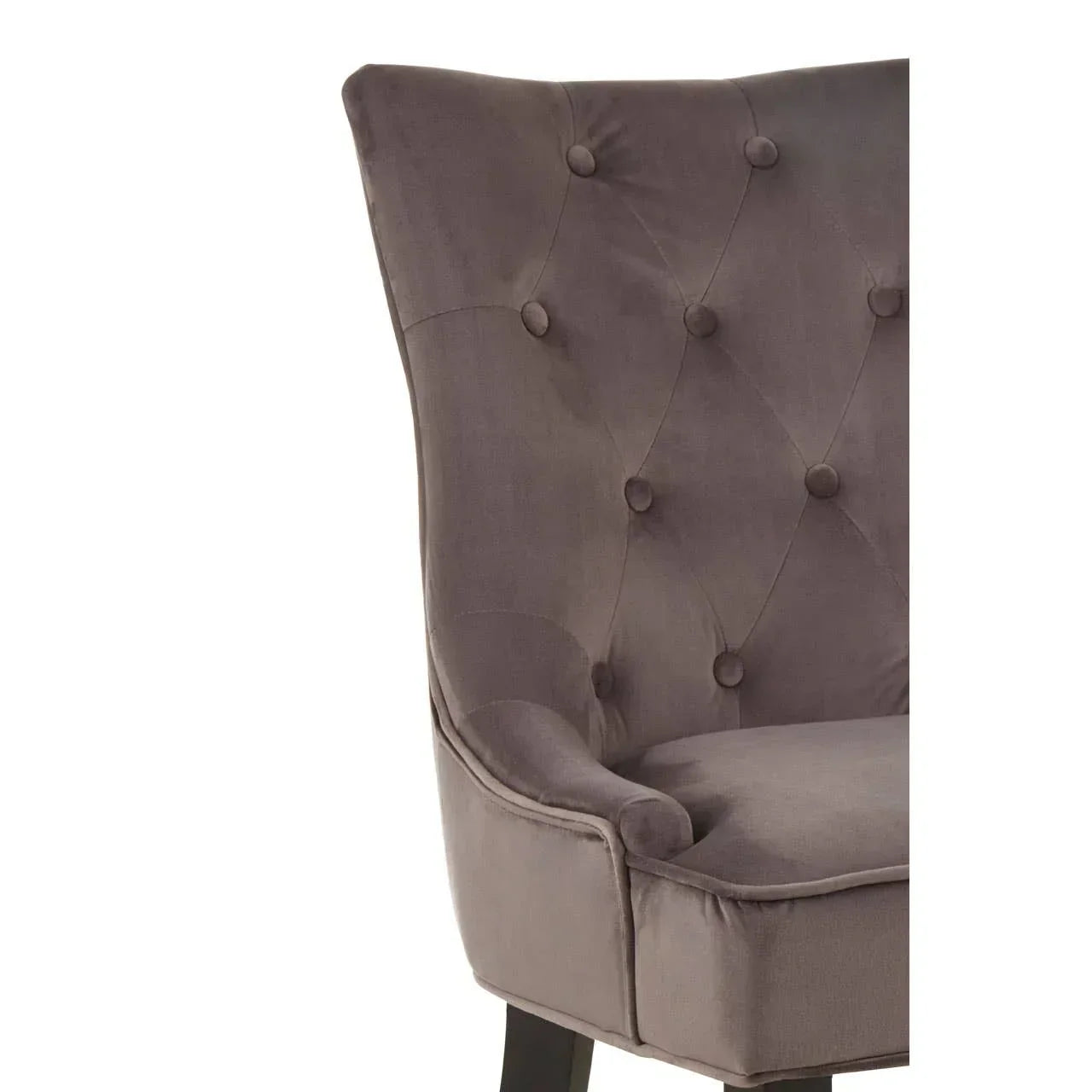 Close-up of grey velvet armchair with button-tufted back and curved seat