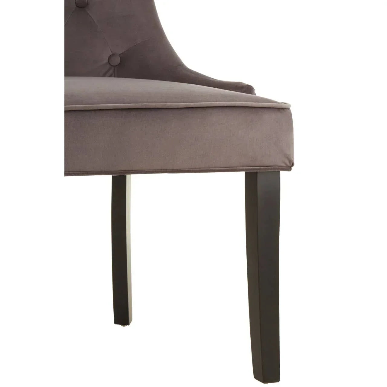 Closeup of grey upholstered dining chair with button detail and black wooden legs