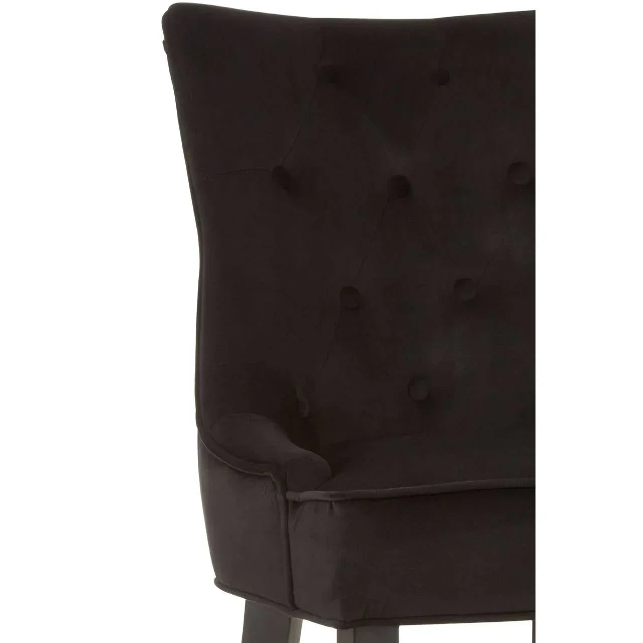 Close-up of black velvet dining chair with tufted backrest and dark wood legs