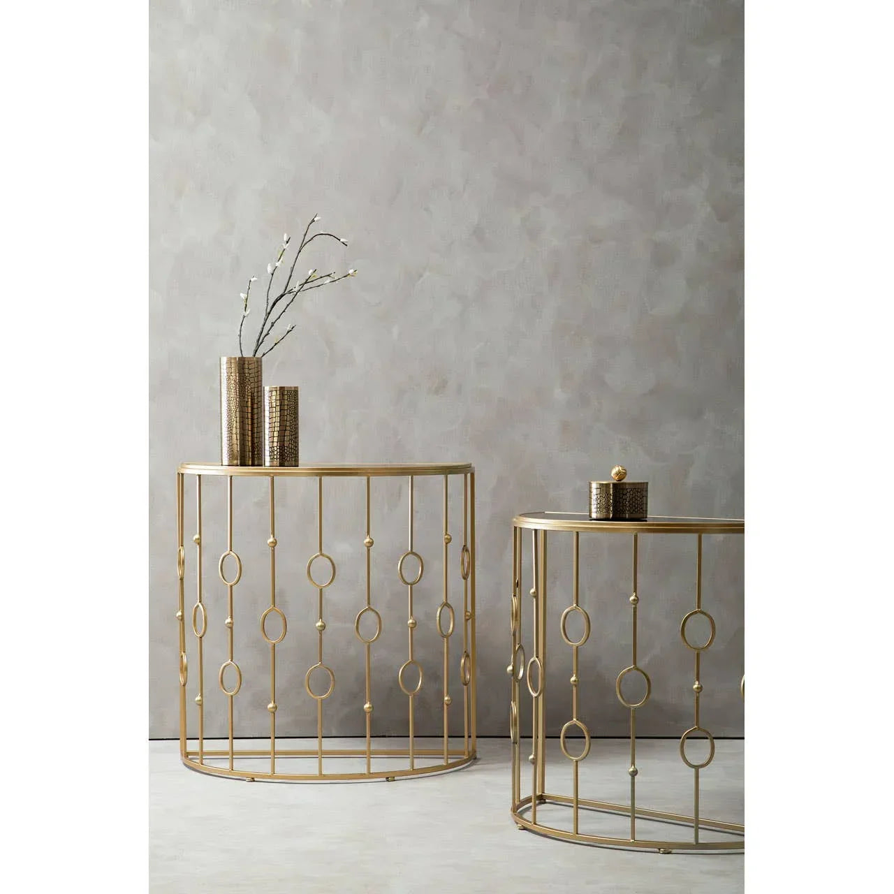 Gold metal console tables with circular geometric frame and decorative vases on top