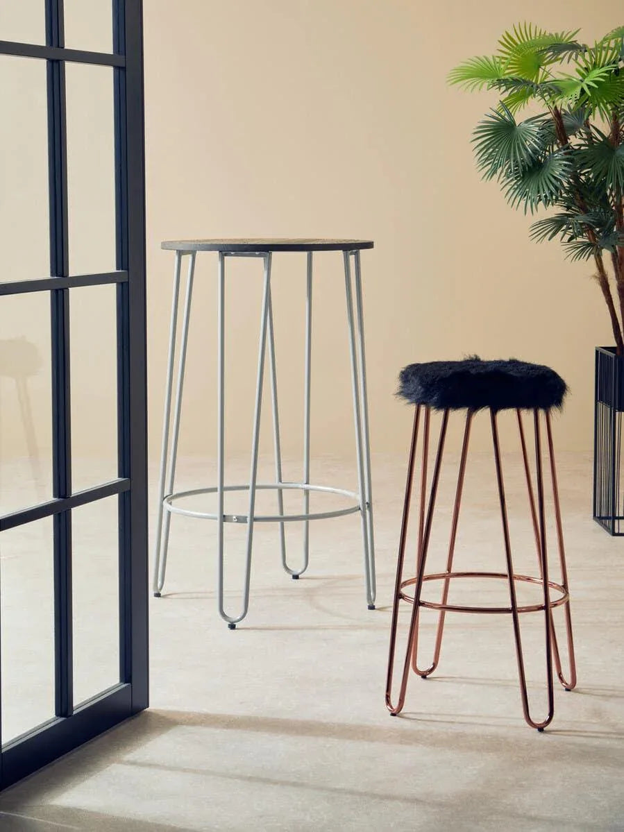 Bar stools with metal frames, one with faux fur seat, in modern living room setting