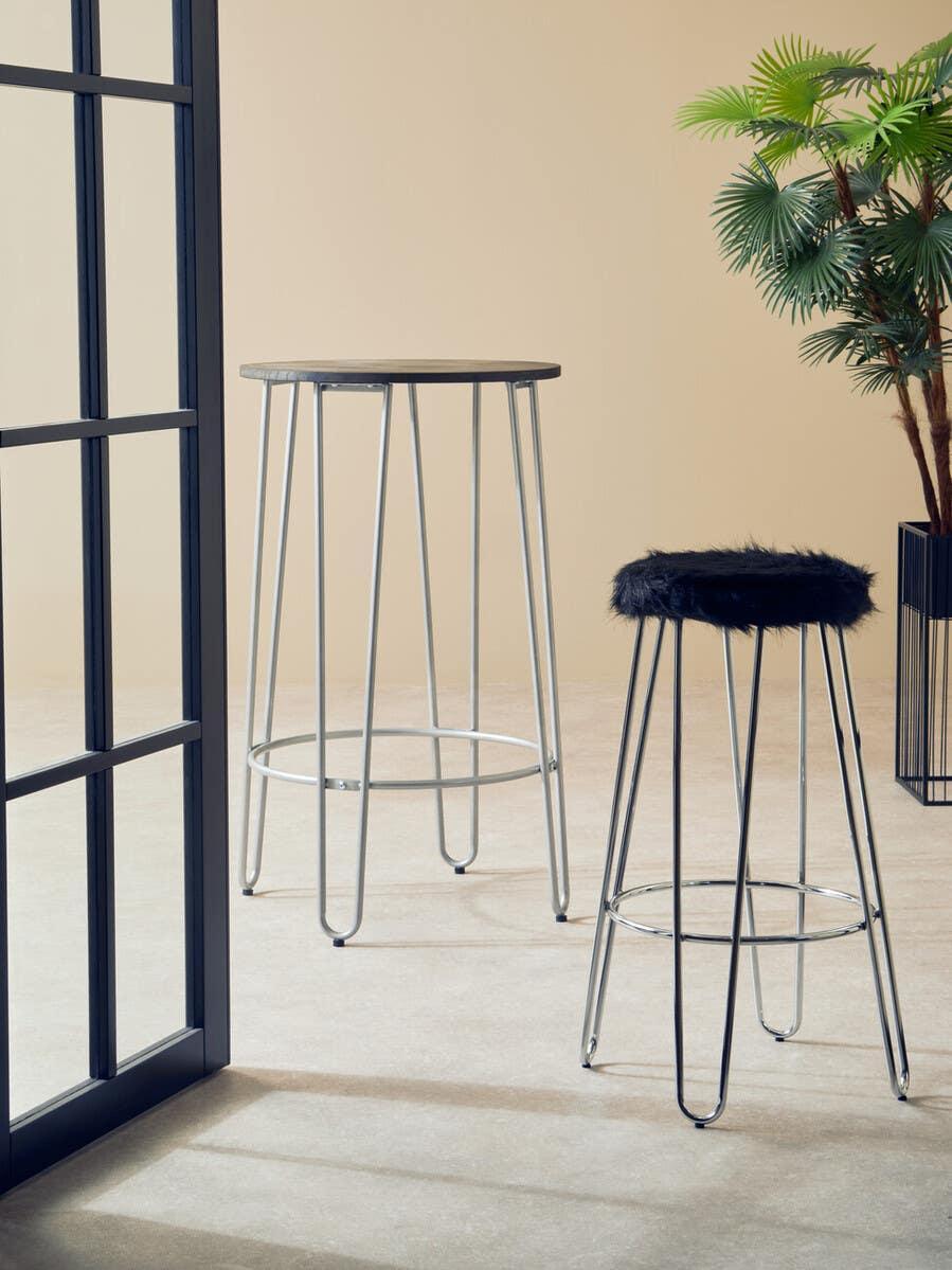 Tall bar table and fur top bar stool with chrome legs in modern indoor setting