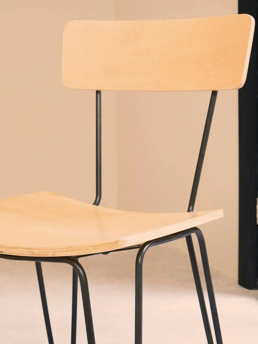 Modern wooden dining chair with black metal legs in minimalist room