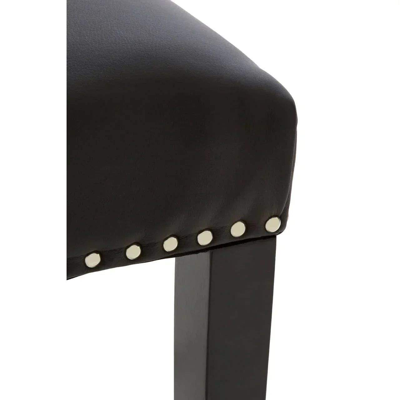Black leather dining chair seat with silver stud detailing and wooden leg closeup