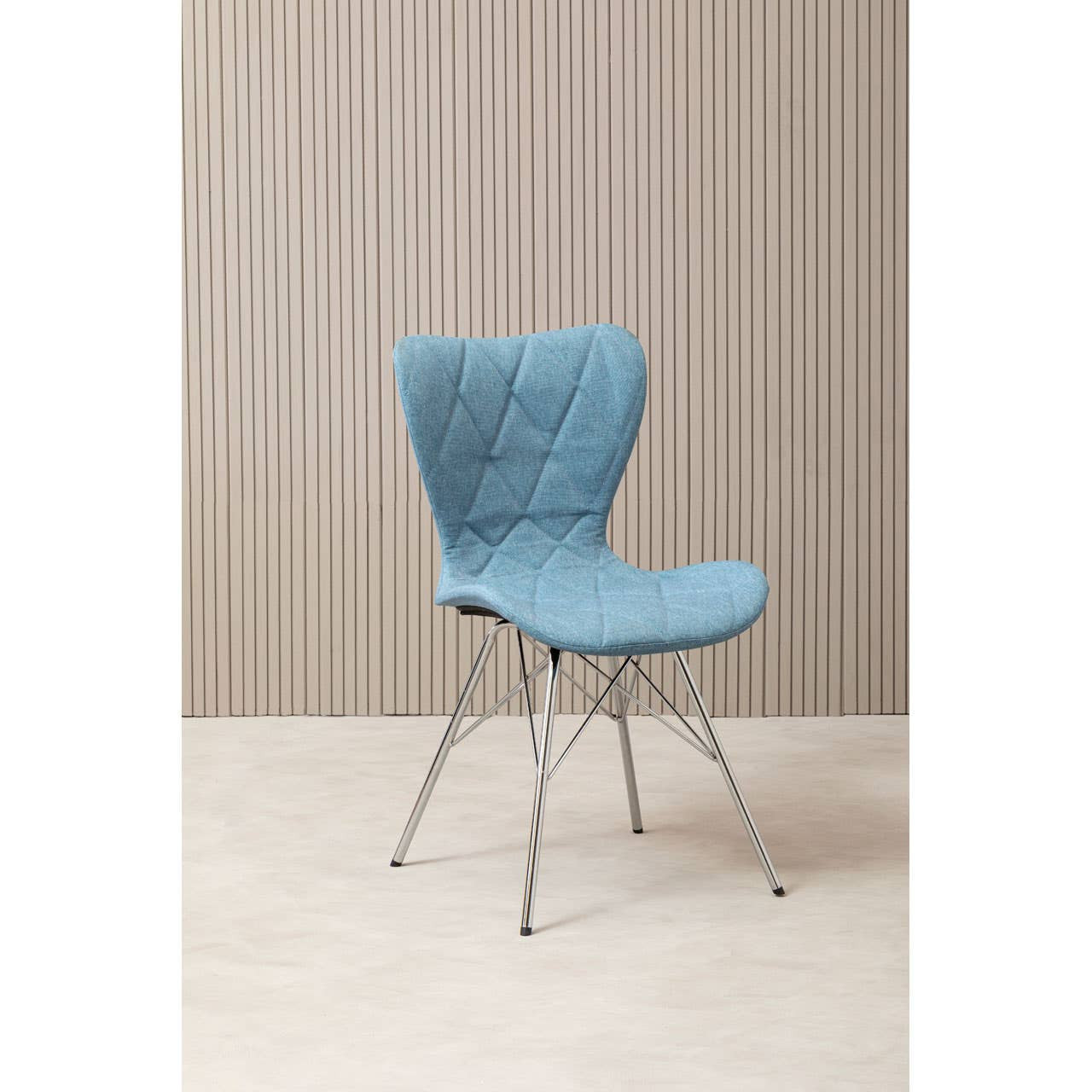 A stylish blue dining chair with a curved backrest and a comfortable seat, supported by sleek metal legs, set against a light wooden wall and a neutral floor