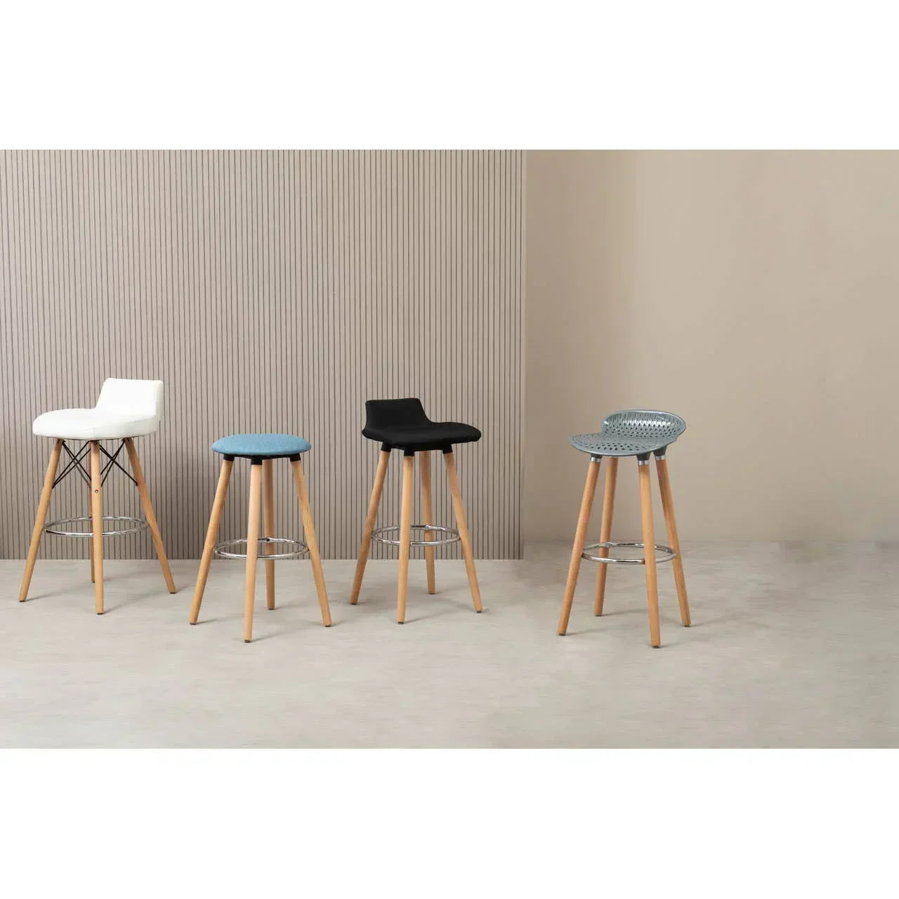 Modern bar stools in assorted colors with wooden legs against neutral wall background